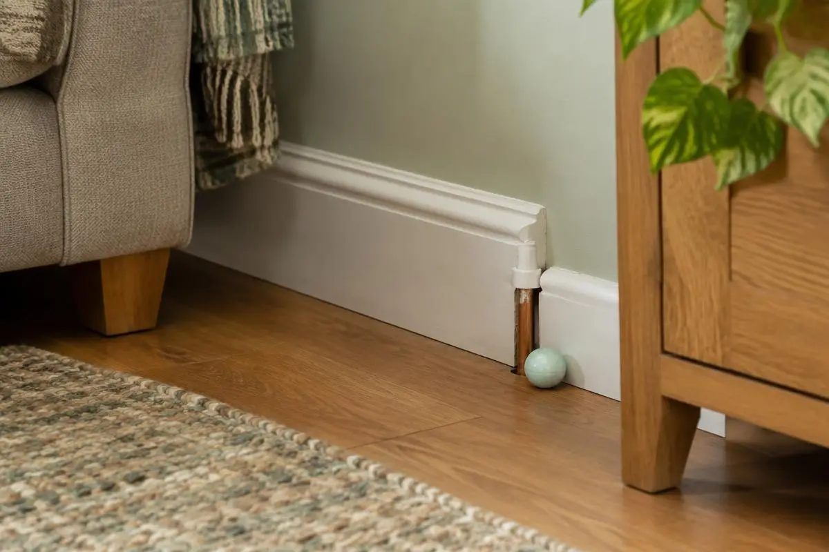 Gap by a pipe in a skirting board with a peppermint ball